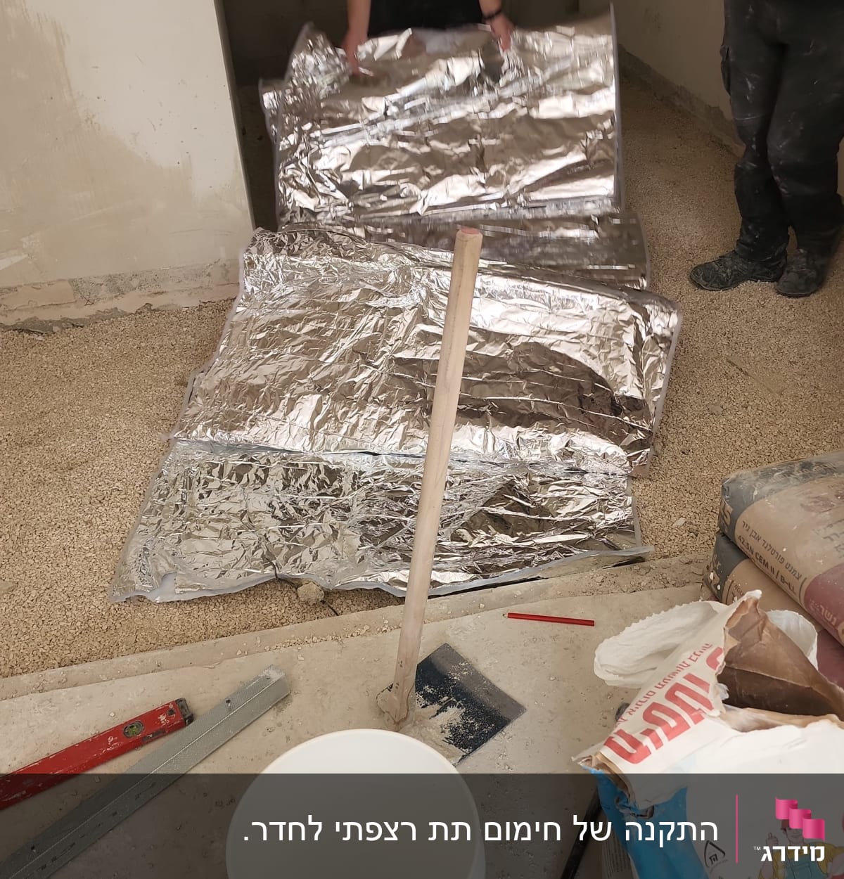 אדם פורש יריעות בידוד על רצפה